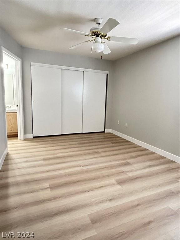 unfurnished bedroom with a closet, a ceiling fan, light wood-type flooring, and baseboards