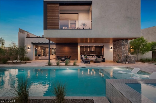 back house at dusk featuring a fenced in pool, an outdoor hangout area, and a patio