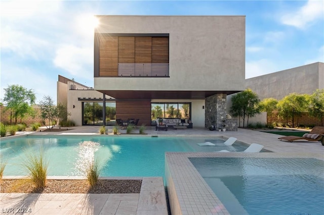 back of house featuring outdoor lounge area and a patio