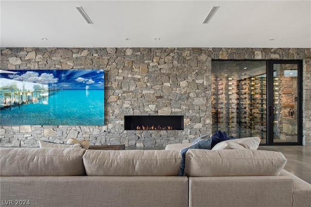 living room with concrete floors and a stone fireplace