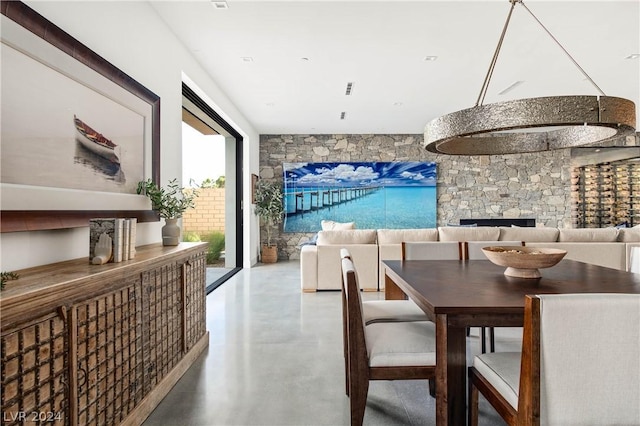 dining space with concrete flooring and a fireplace