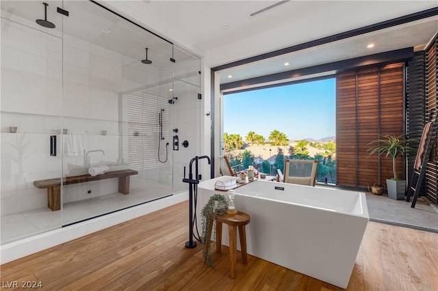 bathroom with separate shower and tub and wood-type flooring