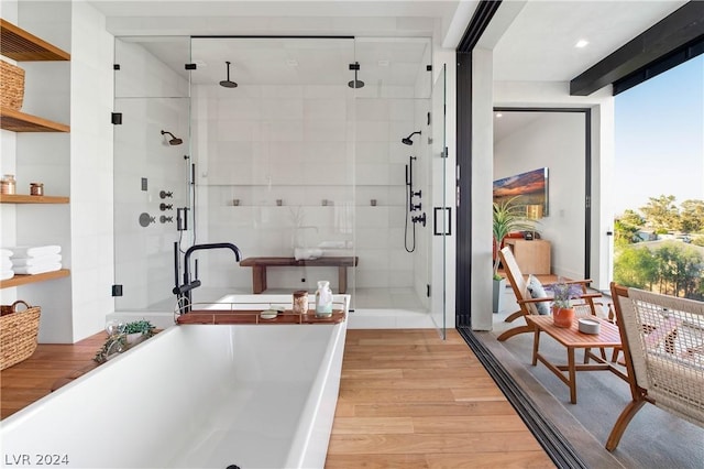 bathroom with hardwood / wood-style flooring, plus walk in shower, and a wealth of natural light