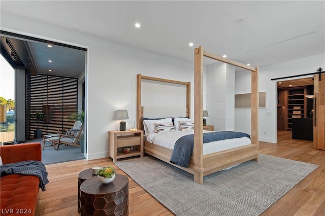 bedroom featuring a barn door and wood-type flooring