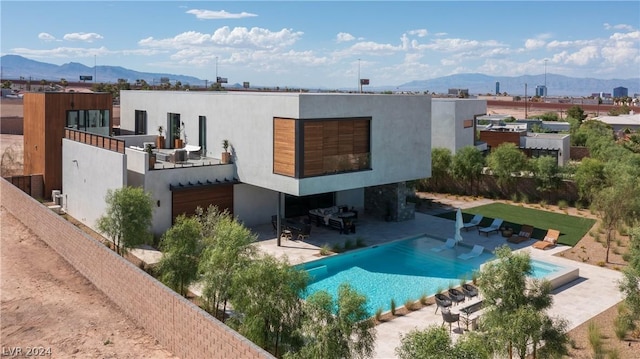 rear view of house featuring a mountain view and a patio