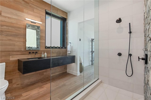 bathroom with tiled shower, tile patterned flooring, and toilet