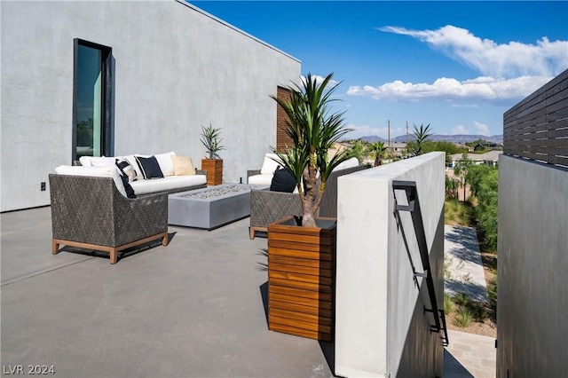 view of patio with an outdoor living space with a fire pit