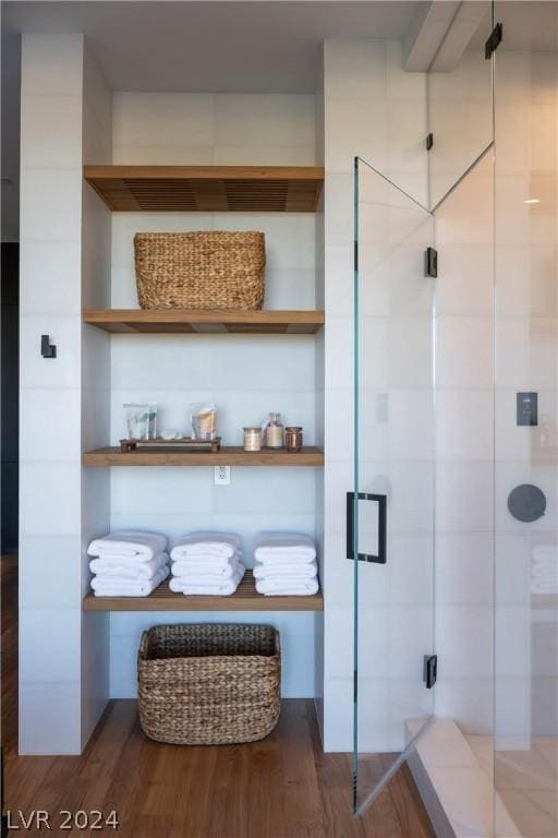 bathroom featuring hardwood / wood-style floors and a shower with shower door