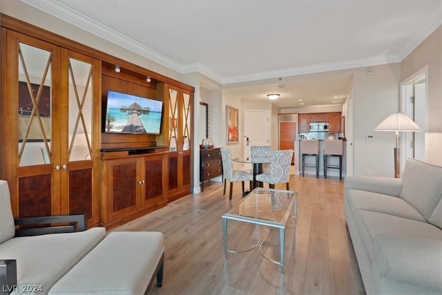 living room featuring light hardwood / wood-style flooring, ornamental molding, and french doors