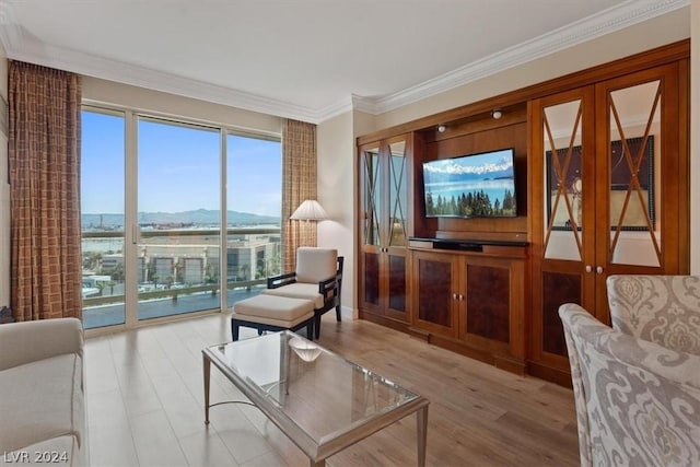 living area with ornamental molding and light wood-style flooring
