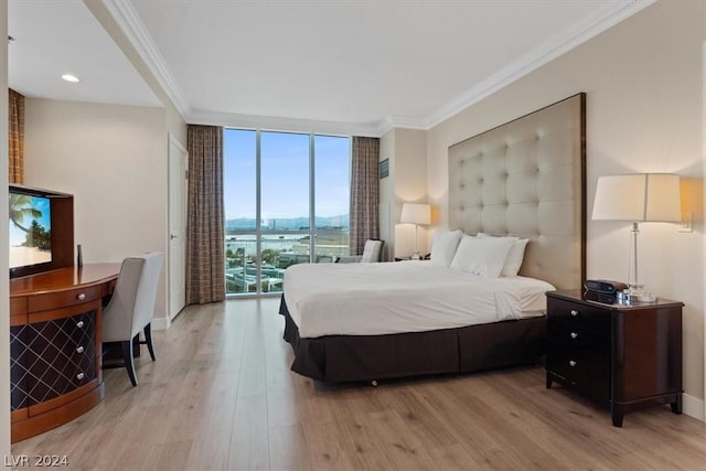 bedroom with crown molding, light wood-type flooring, access to exterior, and a wall of windows