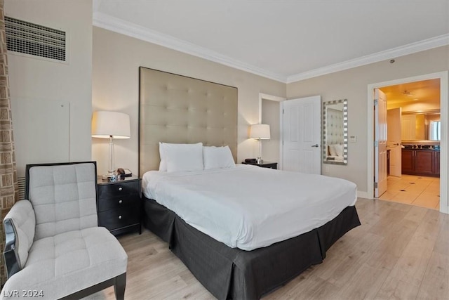 bedroom with ornamental molding, ensuite bathroom, and light hardwood / wood-style flooring