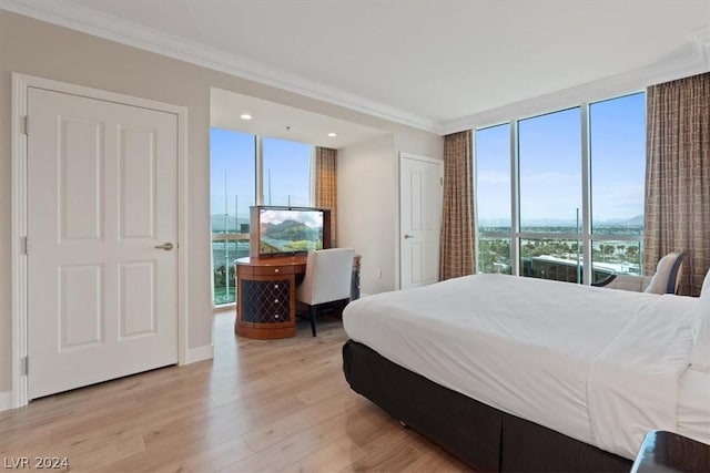bedroom featuring crown molding, light wood-style floors, floor to ceiling windows, and recessed lighting