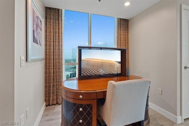 office area with baseboards, wood finished floors, and expansive windows