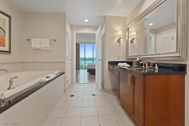 bathroom featuring vanity, tiled bath, and tile patterned flooring