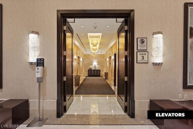 hallway featuring light tile patterned floors and ornamental molding