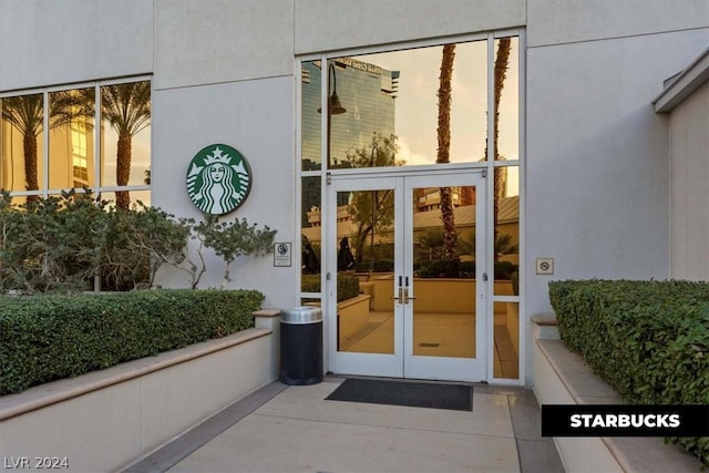 exterior entry at dusk featuring french doors and stucco siding