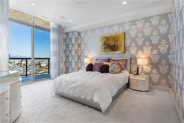 bedroom featuring a wall of windows, access to outside, and light colored carpet