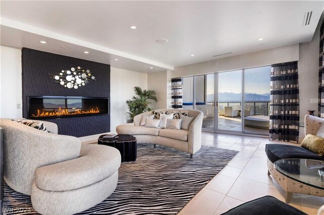 living room with a large fireplace, a mountain view, and tile patterned flooring