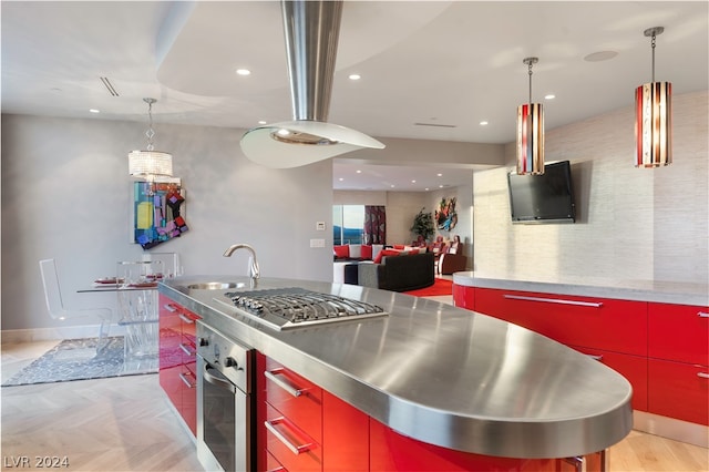 kitchen featuring sink, appliances with stainless steel finishes, pendant lighting, and stainless steel counters