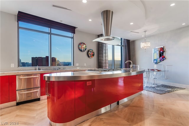 kitchen with stainless steel counters, stainless steel gas stovetop, decorative light fixtures, a kitchen island, and light parquet flooring