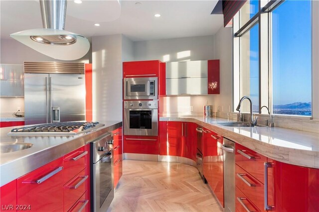 kitchen featuring built in appliances, sink, light parquet floors, and stainless steel counters