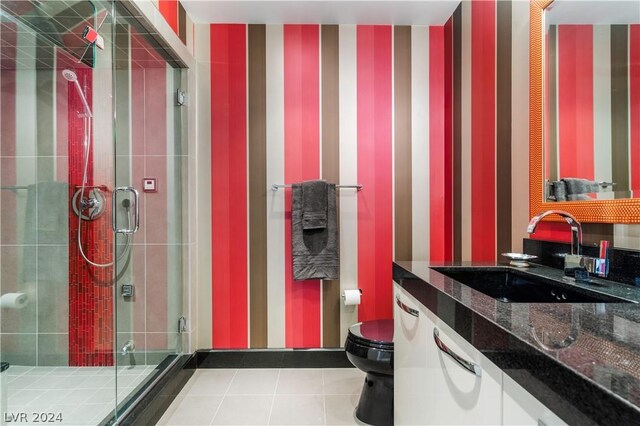 bathroom with tile patterned flooring, a shower with shower door, toilet, and vanity