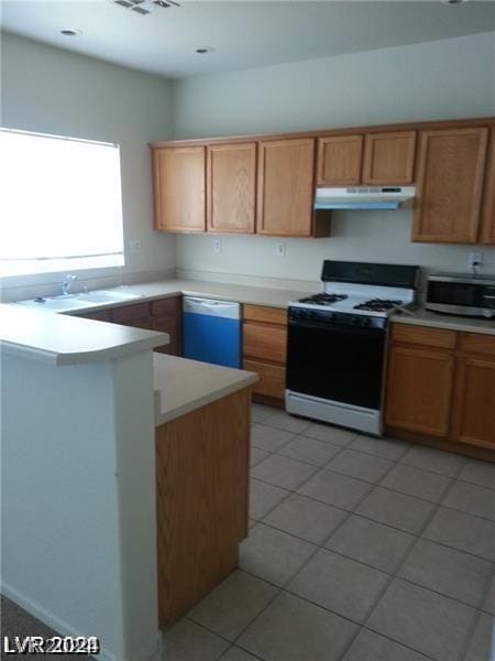 kitchen featuring dishwasher, kitchen peninsula, sink, light tile patterned flooring, and range