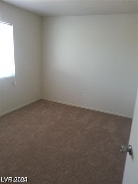 spare room with dark carpet