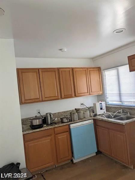 kitchen with white dishwasher, sink, dark hardwood / wood-style floors, and light stone countertops