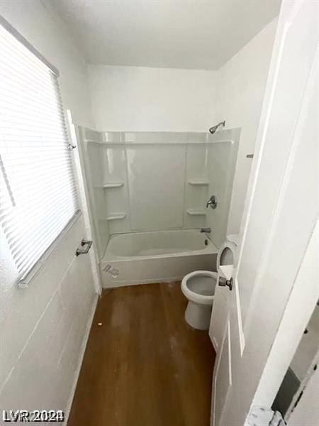 bathroom with shower / tub combination, toilet, and hardwood / wood-style flooring