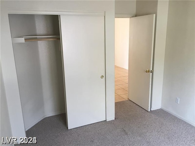 unfurnished bedroom with a closet and light carpet