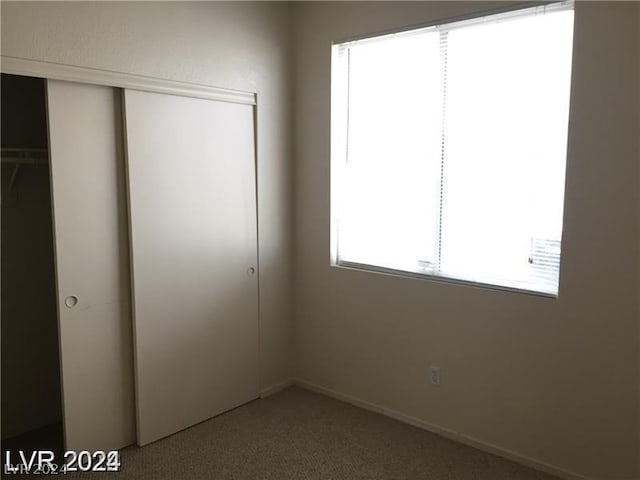 unfurnished bedroom with a closet and carpet flooring