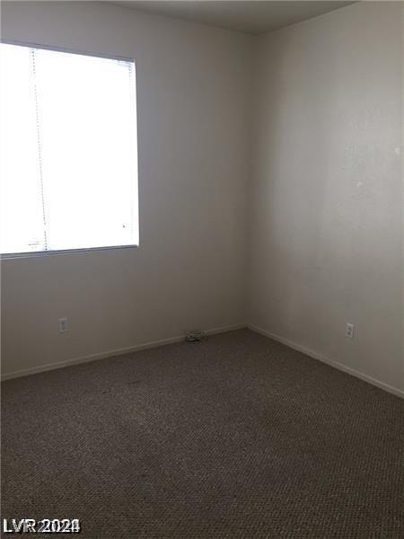 spare room featuring dark carpet