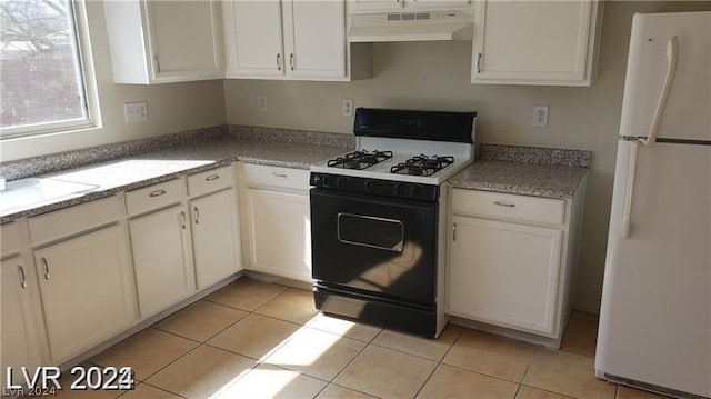 kitchen with white cabinetry, light tile patterned floors, white refrigerator, and range with gas stovetop