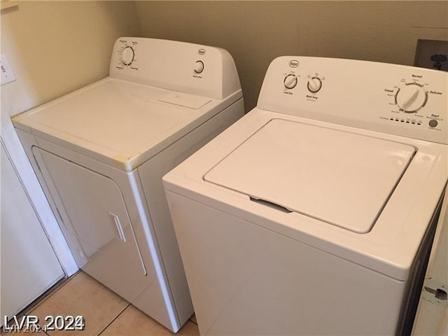 clothes washing area featuring light tile patterned floors and washer and clothes dryer