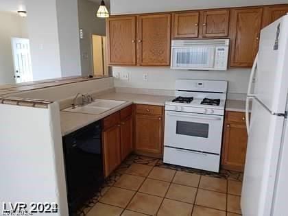 kitchen featuring sink, hanging light fixtures, light tile patterned floors, kitchen peninsula, and white appliances