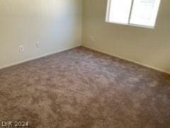 spare room with dark colored carpet