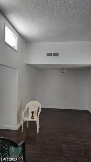 basement featuring dark hardwood / wood-style floors and a textured ceiling