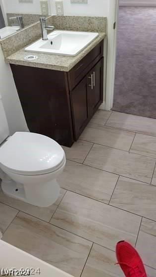 bathroom with vanity, tile patterned flooring, and toilet