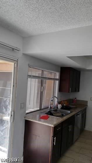 kitchen featuring dark brown cabinetry, sink, a textured ceiling, and dishwasher