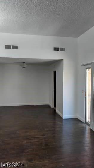 unfurnished room with dark hardwood / wood-style flooring and a textured ceiling