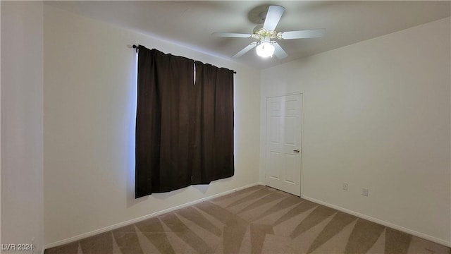 unfurnished room with light carpet, baseboards, and a ceiling fan