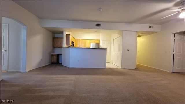 unfurnished living room with a ceiling fan, arched walkways, light carpet, and visible vents