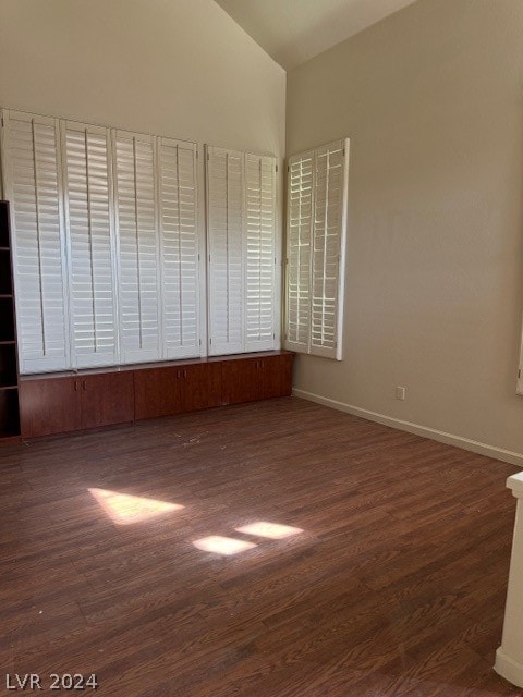 empty room featuring dark hardwood / wood-style flooring and high vaulted ceiling