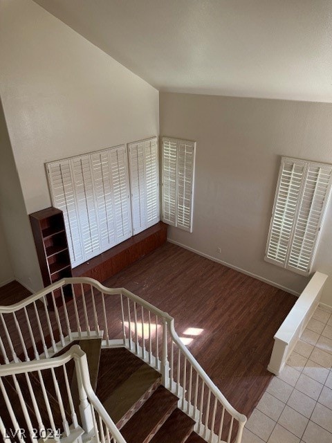 staircase with hardwood / wood-style flooring and vaulted ceiling