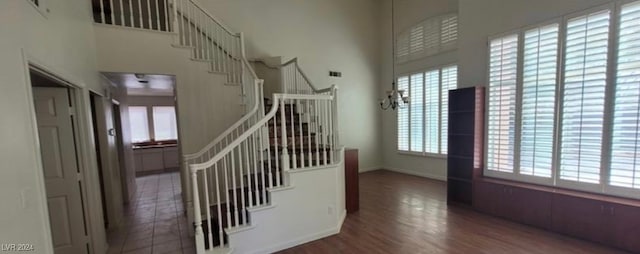 stairway featuring hardwood / wood-style flooring and a high ceiling