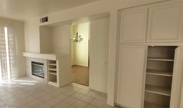 unfurnished living room with a tile fireplace and light tile patterned floors