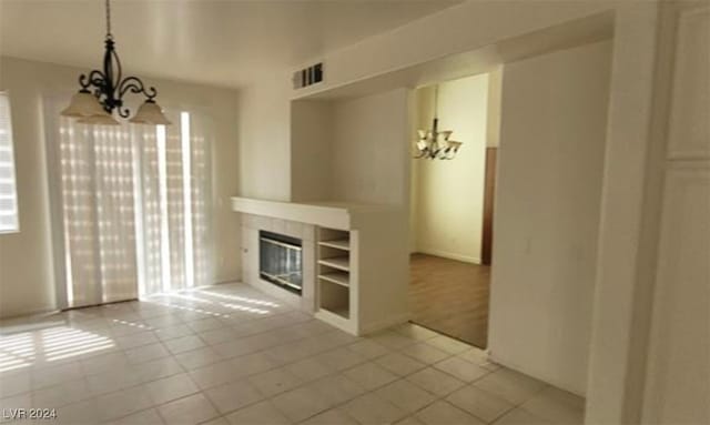 unfurnished living room featuring light tile patterned floors and a notable chandelier