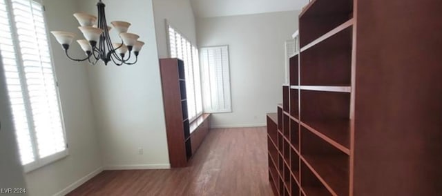 walk in closet featuring a chandelier and dark hardwood / wood-style flooring